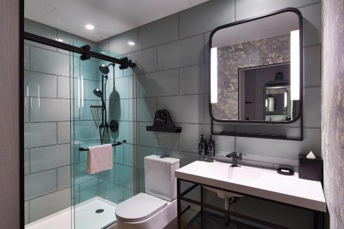 a bathroom with a toilet and a sink and a mirror at Hotel Indigo NYC Financial District, an IHG Hotel in New York