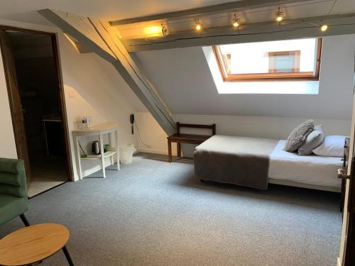 a bedroom with a bed and a skylight at Hotel SPA Au Cheval Blanc in Ribeauvillé