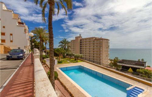 - une piscine à côté d'un bâtiment et de l'océan dans l'établissement Nice Apartment In Santa Pola With Outdoor Swimming Pool, à Santa Pola