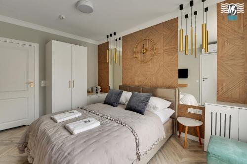 a bedroom with a bed and a clock on the wall at MS Apartments Rest 1.0 in Sopot
