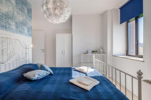a bedroom with a blue bed with two towels on it at Family & Friends Rooms in Padova