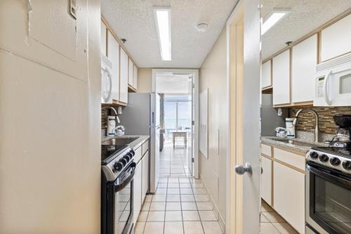 a kitchen with white cabinets and a stove at Ocean Front Comfort 1BR Condo Atlantica in Myrtle Beach