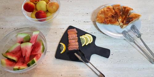 une table recouverte de bols de fruits et d'une assiette de nourriture dans l'établissement Hotel Alexis, à Cluj-Napoca