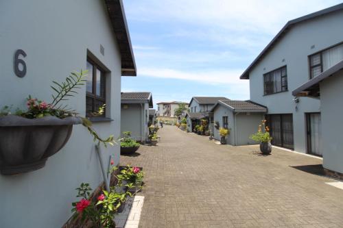 a street of houses with potted plants at Windsor Place 6 in Uvongo Beach