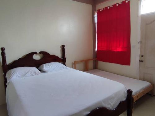 1 dormitorio con 2 camas y una ventana con cortina roja en Iso’s Vacation Rental Apartment #8 en Portsmouth