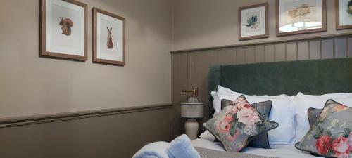 a bedroom with a bed with a green headboard and pillows at The Crown Inn in Coniston