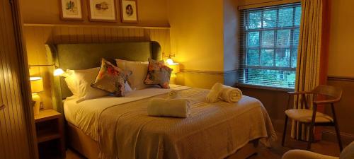 a bedroom with a bed with two towels on it at The Crown Inn in Coniston
