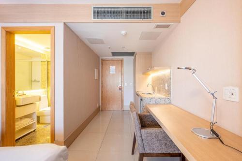 a hotel room with a desk and a bathroom at HOSPEDE-SE JÁ Cullinan Flat Particular in Brasilia
