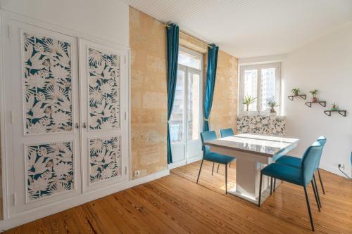 une salle à manger avec une table blanche et des chaises bleues dans l'établissement Large bright duplex in Bordeaux, à Bordeaux