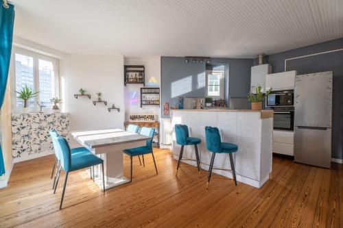 - une cuisine avec une table et des chaises bleues dans l'établissement Large bright duplex in Bordeaux, à Bordeaux