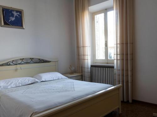 a bedroom with a white bed with a window at Il Glicine in Falerone