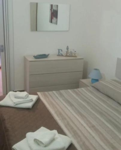 ein Bad mit einem Bett, einem Waschbecken und Handtüchern in der Unterkunft Il tuo nido in Salento in Presicce