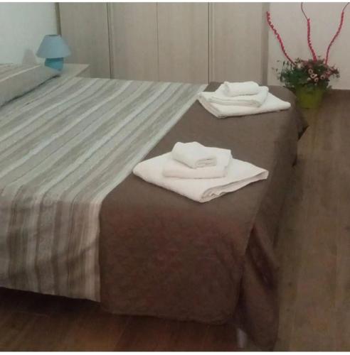 Hay dos toallas blancas encima de una cama. en Il tuo nido in Salento, en Presicce