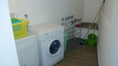 Wäschemöglichkeiten mit einer Waschmaschine und einem Wäschekorb in der Unterkunft Il tuo nido in Salento in Presicce