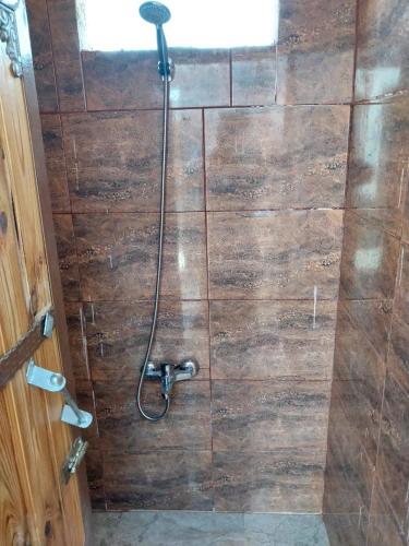 a bathroom with a shower with a wooden wall at Feynan wild camp in Al Khuraybah