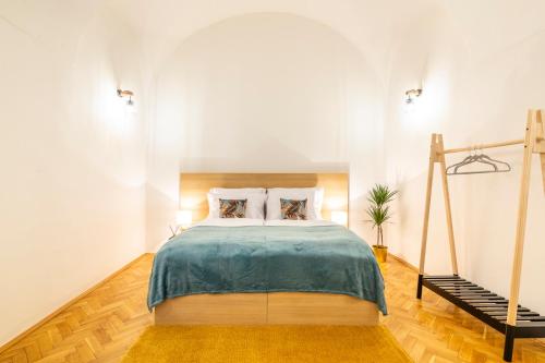a bedroom with a large bed with a blue blanket at Primavera - Castle view apartments in Prague