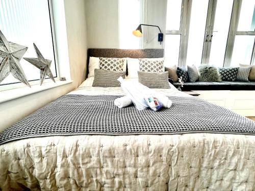 um quarto com uma cama grande com duas toalhas em Beachfront Compact Coastal Crib, DIRECT Sea Views & Air Conditioning em Littlestone-on-Sea