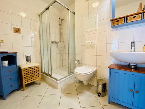 a bathroom with a toilet and a shower and a sink at Dünenresidenz Karlshagen - Ferienwohnung am Gingsterweg in Ostseebad Karlshagen