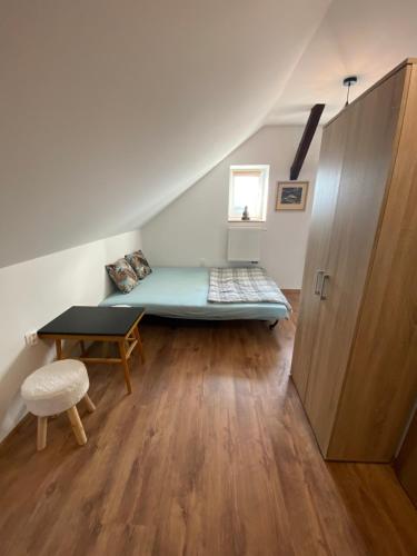 Habitación con cama y mesa en el ático en Apartman 7- Vila Stefanik, en Trenčianska Teplá