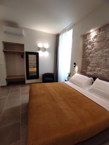 a bedroom with a large bed and a stone wall at La Maison in Trani