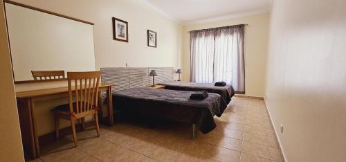 a room with two beds and a desk and a mirror at Open Space - Albufeira in Albufeira