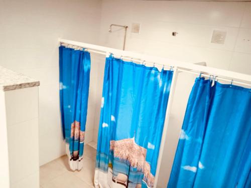 bagno con tende blu per la doccia in camera di Alojamiento Camino Portugues Oia a Villadesuso