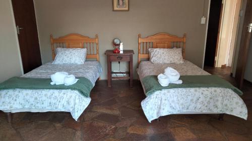 a bedroom with two beds with white towels on them at Doornspruit Farm in Magaliesburg