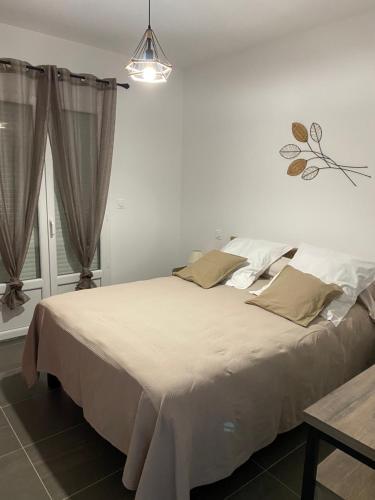 Un dormitorio con una gran cama blanca y una ventana en Résidence Pasturella, en Bastia
