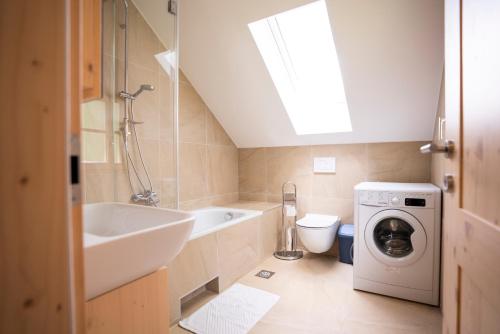 een badkamer met een wastafel en een wasmachine bij Chalet TISA in Bohinj