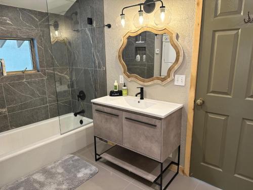 a bathroom with a sink and a mirror and a tub at 3076 W Highway 160 - Guest House in Mancos