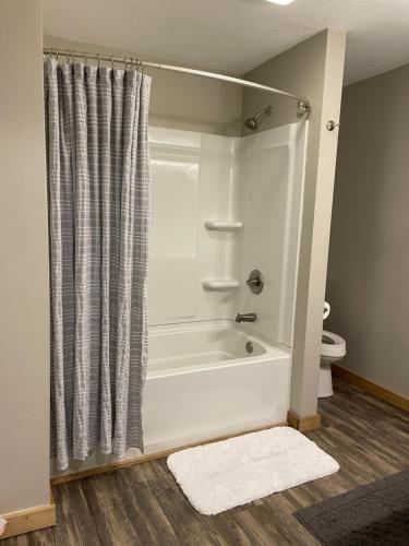a bathroom with a bath tub and a toilet at Modern Farmhouse 3 Bed, 2 Bath Apartment, Sleeps 7, Lots of Space, Steps to Downtown, Honeywell & Eagles Theater in Wabash