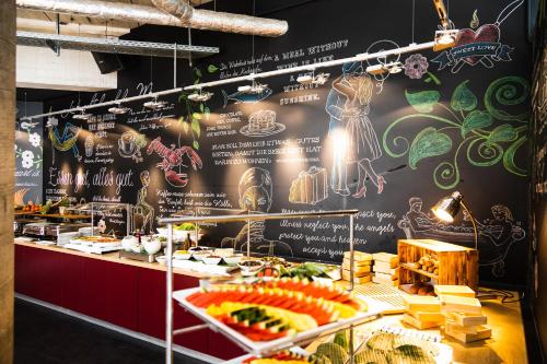 a restaurant with a menu on a wall with food at GINN Hotel Berlin Potsdam in Teltow