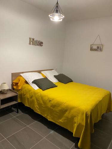 a bed with a yellow blanket on it in a room at Résidence Pasturella in Bastia