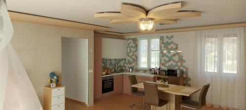 una cucina con tavolo e ventilatore a soffitto di ROZÉ BLUE DESIGN APARTMENTS a Csopak