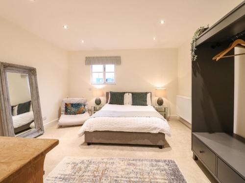 ein Schlafzimmer mit einem Bett und einem Spiegel sowie einem TV in der Unterkunft Walnut View in Rugeley