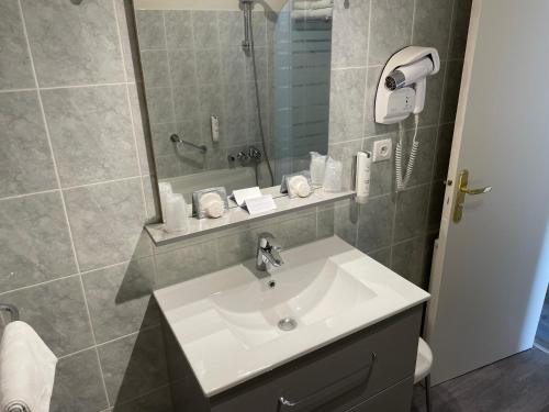 bagno con lavandino bianco e doccia di Appartement Coeur de Ville a Chinon