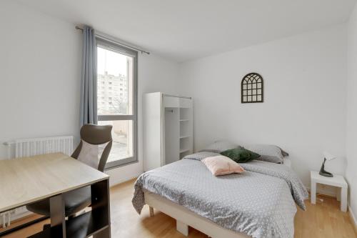1 dormitorio con cama, escritorio y ventana en Budget spacious apart with terrace, en Mantes-la-Jolie