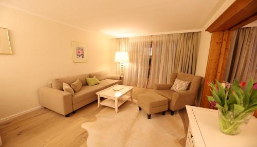 a living room with a couch and a table at Parkhotel am Soier See in Bayersoien