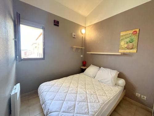 - une petite chambre avec un lit blanc et une fenêtre dans l'établissement appartement 5 personnes résidence piscine 5PB274, au Barcarès