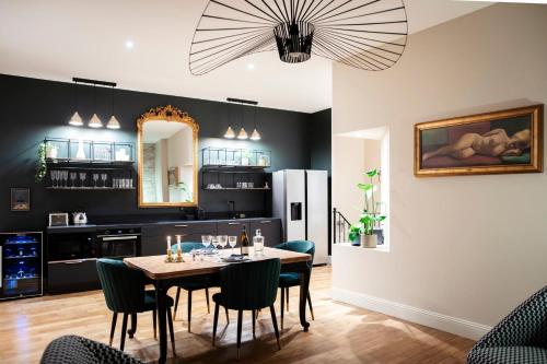 - une salle à manger avec une table et des chaises dans l'établissement Hédoné Suite de luxe et Spa privatif, à Nancy