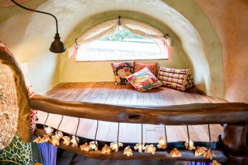 een bed in een kamer met een raam bij 土と音の旅チオンの家 in Onna