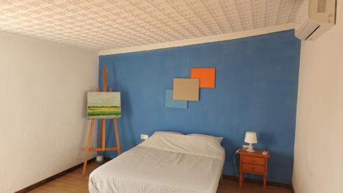 Un dormitorio con una pared azul y una cama en Casa Bounty, en Los Nietos
