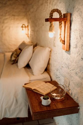 a bed with a wooden table with a cross on the wall at Hotel Fundo El Arrabal in Ica