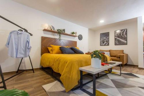 a bedroom with a yellow bed and a couch at Incredible Apartment Avándaro in Valle de Bravo