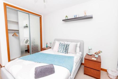 a bedroom with a large bed and a mirror at 'Sunset View' Eclectic & Stylish One Bed Apartment (3 guests) in Fife