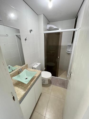 La salle de bains est pourvue d'un lavabo et de toilettes. dans l'établissement Apartamento beira mar em Ponta das Canas, à Florianópolis