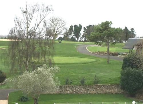 a view of a golf course with a green at Studio Golf piscine D Day in Port-en-Bessin-Huppain