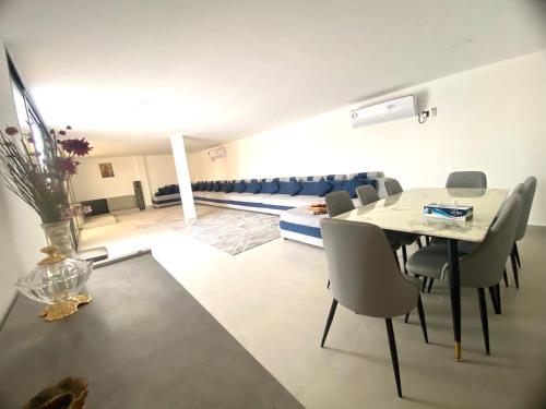 a dining room and living room with a table and chairs at Luxury Farm with Swimming Pool and BBQ in Al Rahba