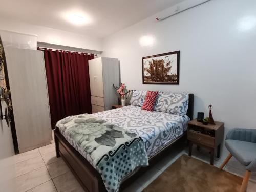 ein Schlafzimmer mit einem Bett und einem roten Vorhang in der Unterkunft RW 5F 5 Cozy 2BR Goshen Land Towers, in Baguio City