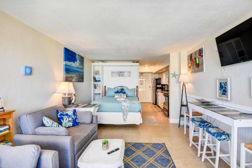 a bedroom with a bed and a living room with a couch at Daytona Beach Studio with Balcony and Ocean View in Daytona Beach